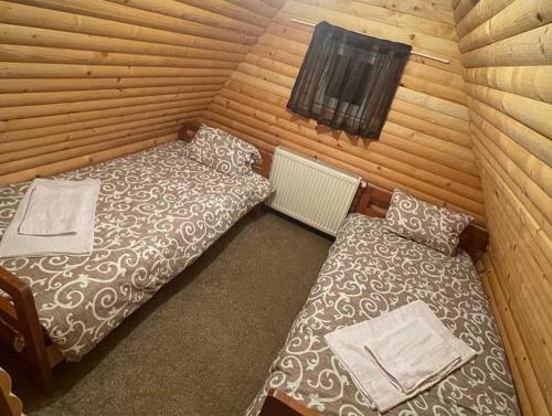 - une chambre avec 2 lits dans une cabane en rondins dans l'établissement Vikendica Golija, à Novi Pazar