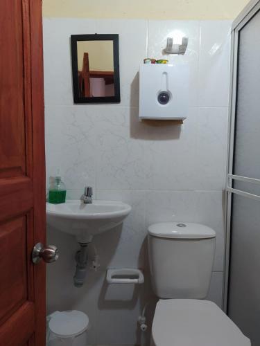 a bathroom with a toilet and a sink at Hotel Orillas del Pizano in Jardin
