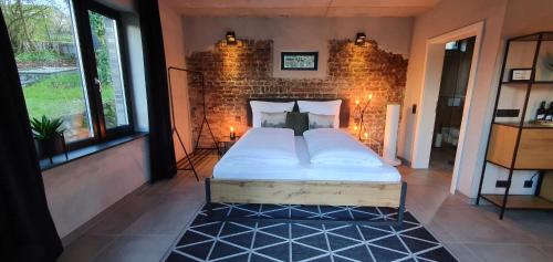 a bed in a room with a brick wall at 1Step2AllNature Tinyhouse in Wuppertal
