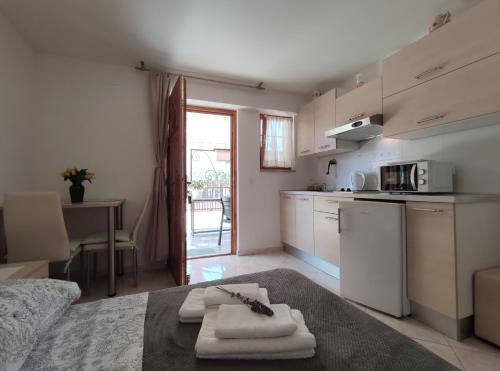 a kitchen with white appliances and a table with towels at Apartmani Rita Studio in Novigrad Istria