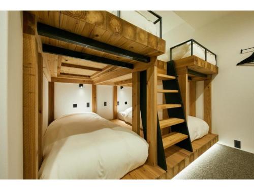 two bunk beds in a room with a ladder at mizuka Daimyo7-unmanned hotel - Vacation STAY 05274v in Fukuoka