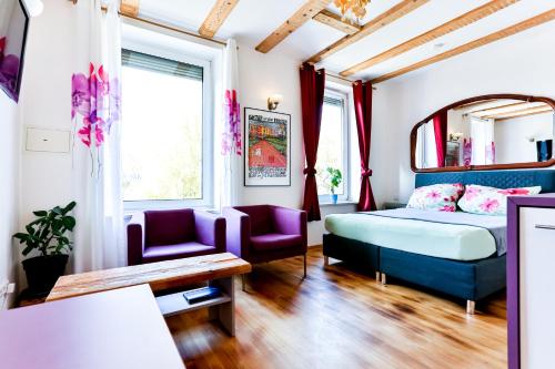 een slaapkamer met een bed en 2 stoelen en een tafel bij A-Apartment in Bad Säckingen