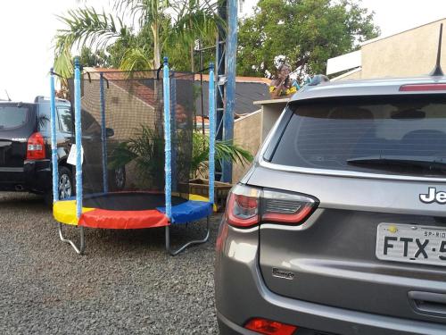 a car parked in a parking lot with a swing at Pousada Flores em Vida in Olímpia