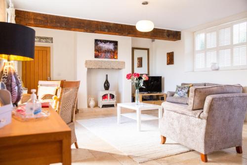 a living room with a couch and a fireplace at Higher Weddicott Barn Holiday Cottage - Self Catering in Chagford