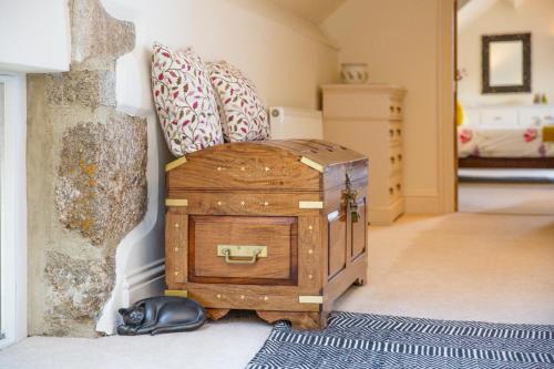 a dog laying on the floor next to a wooden trunk at Higher Weddicott Barn Holiday Cottage - Self Catering in Chagford