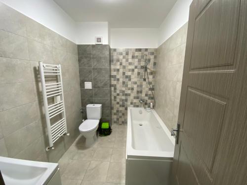 ein Badezimmer mit einer Badewanne, einem WC und einem Waschbecken in der Unterkunft Renting Solutions Deluxe in Iaşi