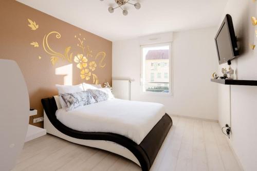 1 dormitorio con 1 cama y TV en la pared en Spacieux - 4 pers' - Balcon - 2 lits - Parking, en Woippy