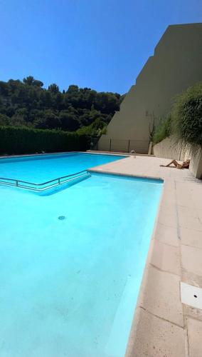 une grande piscine avec de l'eau bleue dans l'établissement Appartement Luxe - 3 pièces avec vue mer, piscine et tennis, à Nice