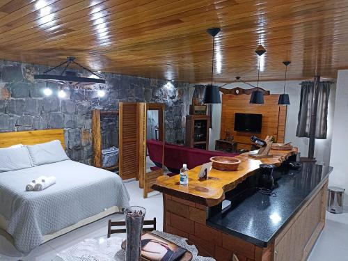 a bedroom with a bed and a tub in it at Aconchego da Serra Edícula in São Joaquim