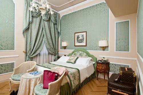 a bedroom with a bed and chairs in a room at Grand Hotel Majestic gia' Baglioni in Bologna