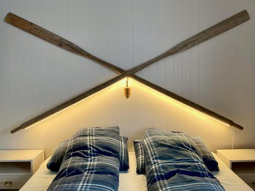 a bed with two pillows and a light on it at Fredvang Panorama Lofoten in Fredvang