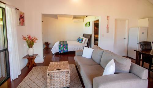 a living room with a couch and a bed at Vai Villas in Avarua