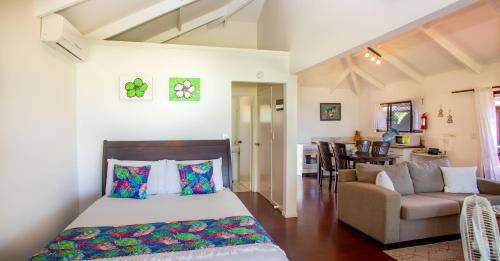 a bedroom with a bed and a living room at Vai Villas in Avarua