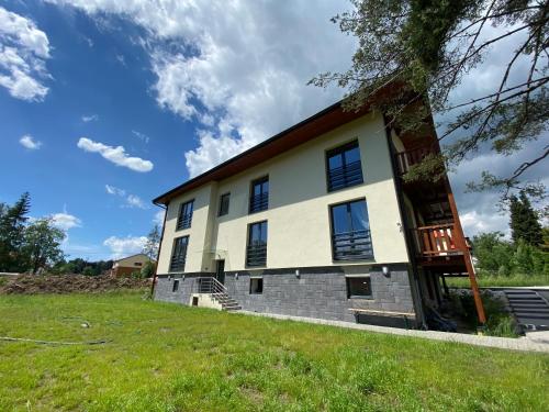 a house on a hill with a green field at 3 Sosny Apartments - Suite 1 in Tatranska Strba