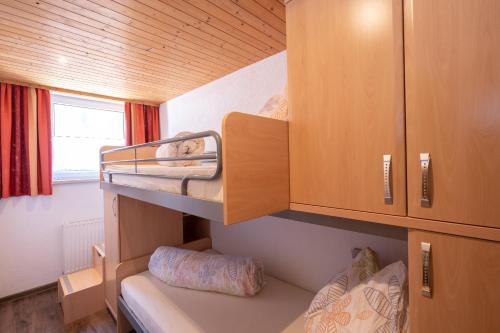 a small room with bunk beds and a window at Eggerhof in Mallnitz