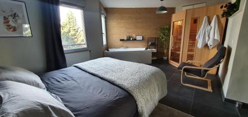 een slaapkamer met een bed en een badkamer met een wastafel bij La Perle du Semnoz in Annecy