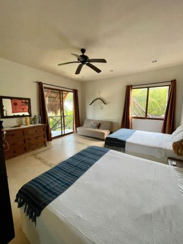 a bedroom with two beds and a ceiling fan at Luxury Ocean Front Villa - Adults Only in Holbox Island