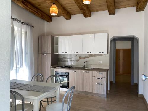 a kitchen with white cabinets and a table with chairs at Appartamento da Antonio in Parghelia
