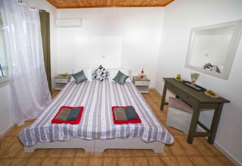 a bedroom with a large bed and a desk at Villa Elpida in Agios Georgios