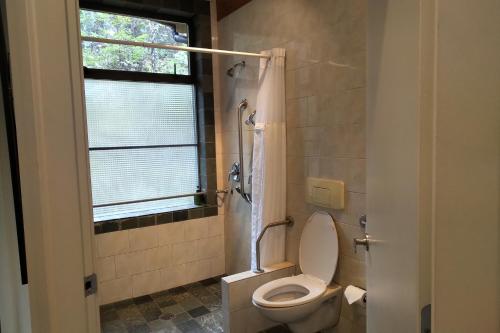 a bathroom with a toilet and a window and a shower at Moon Dance Perch in Madeira Park