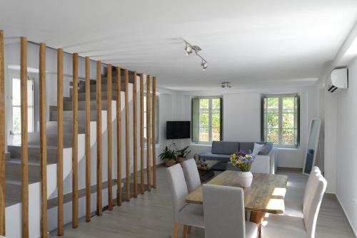 a living room with a staircase with a table and chairs at FAMILY in Spetses
