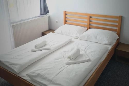 a large white bed with two white towels on it at Apartments and Rooms Ski in Vlasic