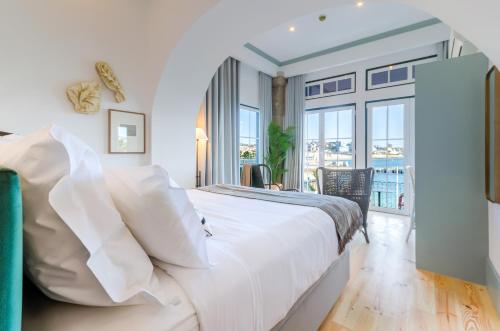 a white bedroom with a large bed and a balcony at Westlight Cascais Chalet - Adults Only in Cascais