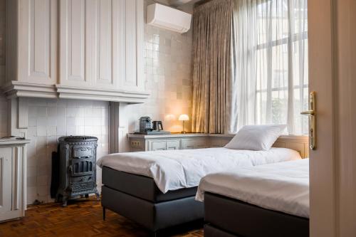 a bedroom with two beds and a stove at De Olde Signorie in Leeuwarden