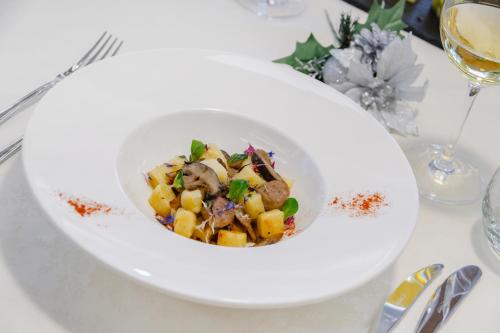 a white bowl of food on a white table at Hotel Ramon in Campitello di Fassa