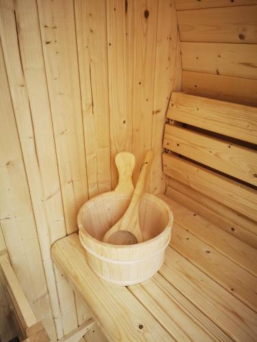 a wooden tub in a sauna with a wooden spoon at Ferienhaus Sonja in Donnerskirchen