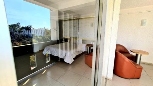 a room with a balcony with a table and a couch at Hotel Borda Cuernavaca in Cuernavaca