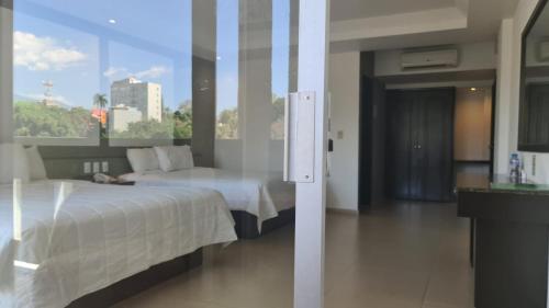 a hotel room with a bed and a large window at Hotel Borda Cuernavaca in Cuernavaca