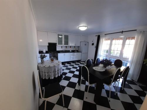 a kitchen and dining room with a table and chairs at Quintinha da Romana in Câmara de Lobos