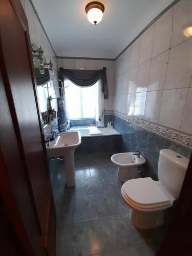 a bathroom with two sinks and a toilet and a tub at Quintinha da Romana in Câmara de Lobos