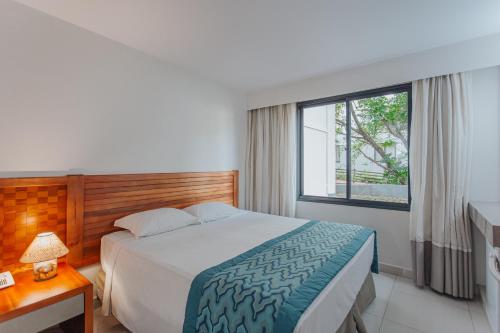 um quarto de hotel com uma cama e uma janela em Rio Quente Resorts - Hotel Luupi em Rio Quente