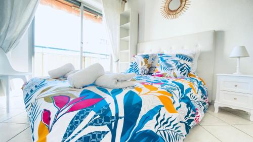 - une chambre avec un lit doté d'un couvre-lit tropical dans l'établissement DELMAS - T3 VUE MER - Parc, Base loisirs, Bus Sophia Antipo, à Antibes