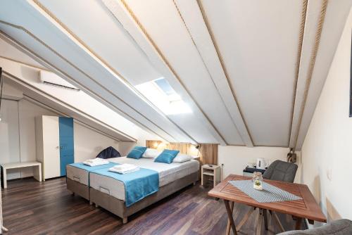 a bedroom with a bed and a table at Nautica Room North - Old Town in Dubrovnik