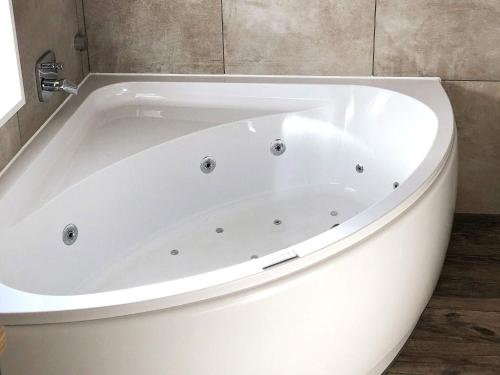 a white bath tub sitting in a bathroom at Three-Bedroom Holiday home in Grömitz 19 in Grömitz