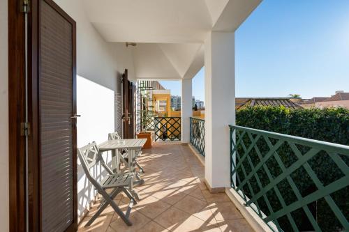 a balcony with a table and chairs on a building at Holiday villa in elite residential area of Faro in Faro