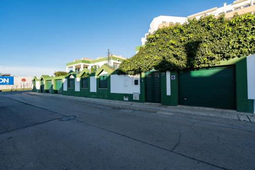 a row of green garages on the side of a street at Holiday villa in elite residential area of Faro in Faro