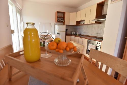 a table with a bowl of oranges and a large orange juice at Holiday Home in Komarna