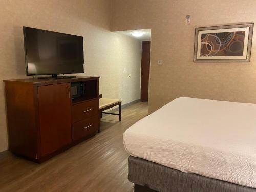 a hotel room with a bed and a flat screen tv at Wyndham Garden Grand Rapids Airport in Grand Rapids