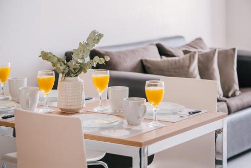 une table avec des verres de jus d'orange et un canapé dans l'établissement La Vela, à Ushuaia