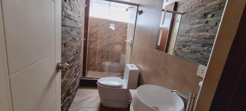 y baño con aseo, lavabo y ducha. en Hostal Montalvo, en Moquegua