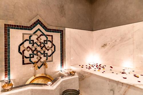 La salle de bains est pourvue d'une baignoire et d'un mur en carrelage. dans l'établissement Riad Luciano Hotel and Spa, à Marrakech