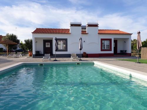 a villa with a swimming pool in front of a house at Casas da Minh'Alma in Reguengos de Monsaraz