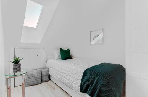 ein weißes Schlafzimmer mit einem Bett und einem Glastisch in der Unterkunft Condo Ski-In Ski-Out Stoneham in Stoneham