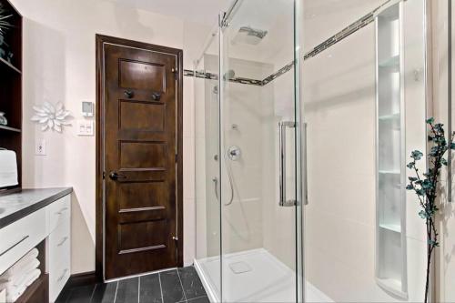 uma casa de banho com um chuveiro e uma porta de vidro em Condo Ski-In Ski-Out Stoneham em Stoneham