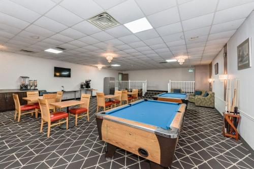 a pool table in a room with tables and chairs at King Hotel in Palmerston