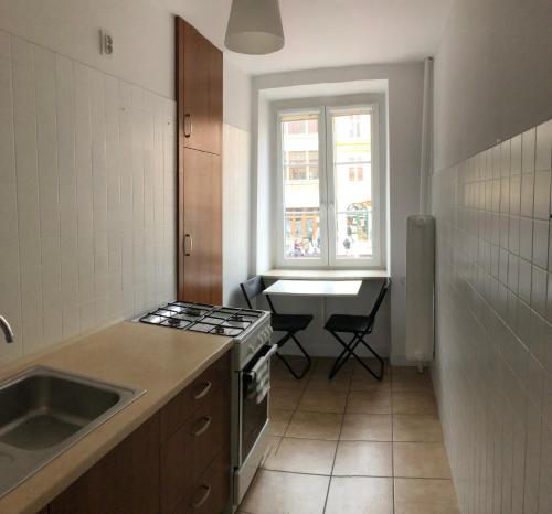 kuchnia z kuchenką, umywalką i oknem w obiekcie Apartament Central Nº1 we Wrocławiu